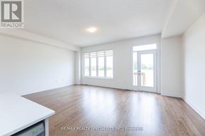 Brampton (Bram West) townhouse for rent - A spacious room with wooden flooring and white walls.