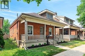 Brantford apartment for rent - A red brick house with a white porch and a mailbox on the front.