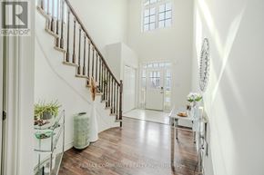 Fort Erie (Crescent Park) apartment for rent - A hallway with a staircase and a table with flowers on it.