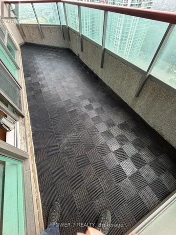 Toronto (Bendale) condo for rent - A person is standing on a black tiled floor with glass walls on the sides.