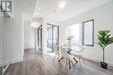 Vaughan (Vaughan Corporate Centre) condo for rent - A modern living room with a glass table and chairs.