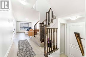 Oshawa (Taunton) townhouse for rent - A hallway with a staircase and a rug on the floor.