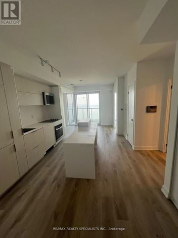 Burlington (Brant) condo for rent - A modern kitchen with white cabinets and a wooden floor.