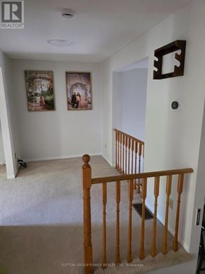 Brampton (Fletcher's Creek South) townhouse for rent - A hallway with a wooden railing and two pictures on the wall.