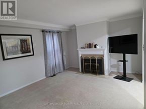 Brampton (Fletcher's Creek South) townhouse for rent - A living room with a fireplace and a flat screen TV.