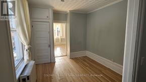 Ottawa fourplex for rent - A room with wooden floors and a white door.