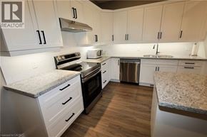 Seaforth townhouse for rent - A kitchen with white cabinets and a granite countertop.