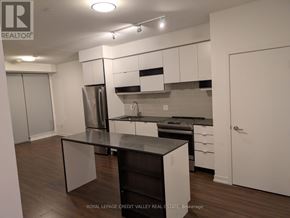 Mississauga (City Centre) condo for rent - A kitchen with white cabinets and a black countertop.