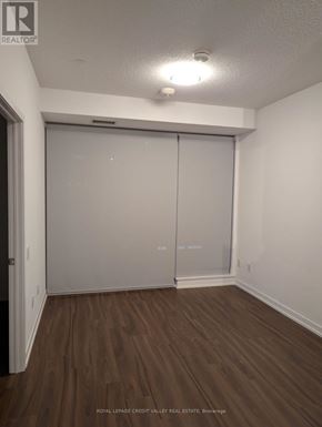 Mississauga (City Centre) condo for rent - A room with a sliding door and wooden flooring.