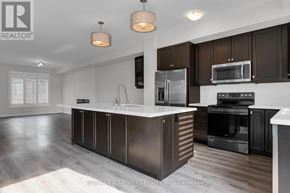 Grimsby (Grimsby Beach) townhouse for rent - A modern kitchen with dark brown cabinets and stainless steel appliances.
