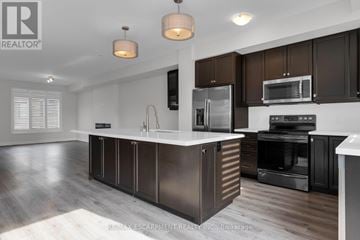 Grimsby (Grimsby Beach) townhouse for rent - A modern kitchen with dark brown cabinets and stainless steel appliances.