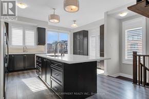 Grimsby (Grimsby Beach) townhouse for rent - A modern kitchen with black cabinets and a large island.