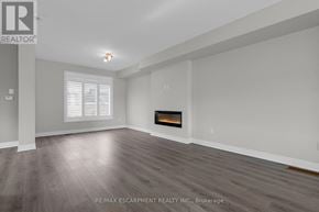 Grimsby (Grimsby Beach) townhouse for rent - A spacious room with a fireplace and wood flooring.