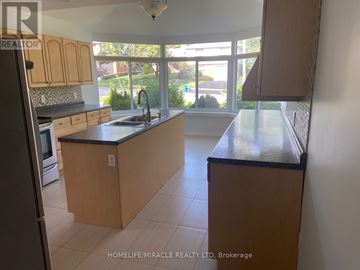 Kitchener apartment for rent - A kitchen with wooden cabinets and a black countertop.