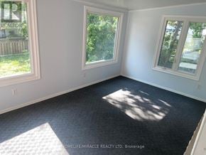 Kitchener apartment for rent - A room with a carpeted floor and three windows.
