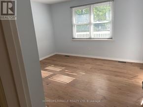 Kitchener apartment for rent - A room with wooden flooring and a window with blinds.