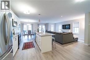 Kitchener townhouse for rent - A modern kitchen with a refrigerator, sink, and a dining area with a couch and chairs.
