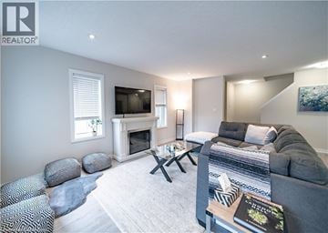 Kitchener townhouse for rent - A living room with a grey couch and a fireplace.
