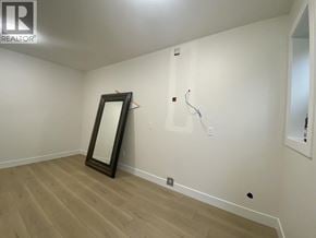 Burnaby apartment for rent - A room with a wooden floor and a mirror on the wall.