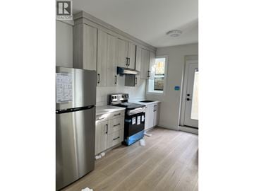 Burnaby apartment for rent - A kitchen with a stainless steel refrigerator and wooden cabinets.