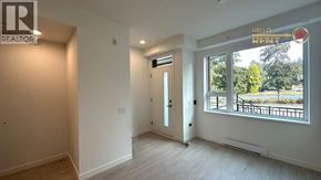 North Vancouver townhouse for rent - A room with a door and a window with a view of trees and a fence outside.