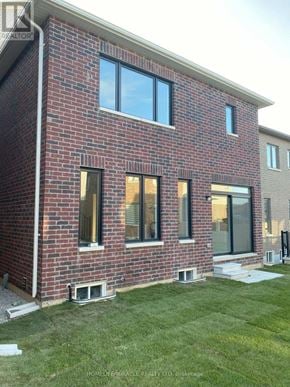 Barrie (Innis-Shore) apartment for rent - A red brick house with a white roof and a green lawn in front.