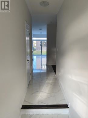 Barrie (Innis-Shore) apartment for rent - A long hallway with white walls and marble floors.