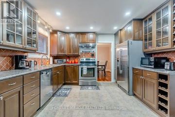 Halton Hills (Rural Halton Hills) apartment for rent - A kitchen with wooden cabinets and a brick backsplash.