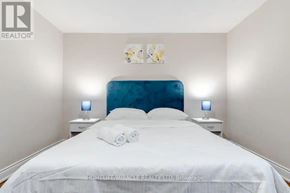 Halton Hills (Rural Halton Hills) apartment for rent - A bedroom with a white bed and blue headboard.