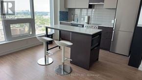 Toronto (Kensington-Chinatown) condo for rent - A modern kitchen with a bar stool in front of a window.