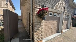 Brampton (Fletcher's Creek South) apartment for rent - A house with a brown garage door and a brick wall.