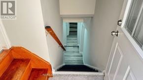 Brampton (Fletcher's Creek South) apartment for rent - A staircase with a wooden handrail leads to a brightly lit hallway.
