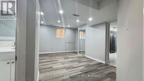 Brampton (Fletcher's Creek South) apartment for rent - A spacious room with wooden flooring and white walls, with a glass door leading to another room.