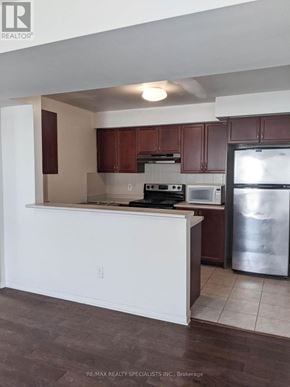 Mississauga (Churchill Meadows) townhouse for rent - A kitchen with white countertops and brown cabinets.