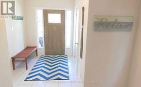 Fort Erie (Crystal Beach) apartment for rent - A hallway with a wooden door and a sign that says "relax".