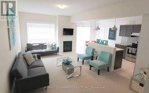 Fort Erie (Crystal Beach) apartment for rent - A living room with a couch, chairs, and a television.