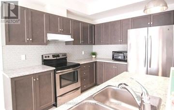 Fort Erie (Crystal Beach) apartment for rent - A kitchen with brown cabinets and a stainless steel refrigerator.