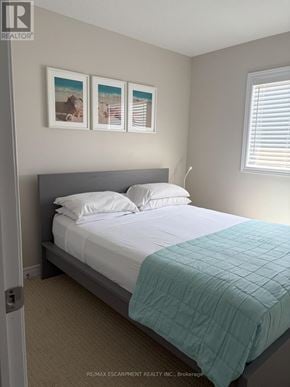 Fort Erie (Crystal Beach) apartment for rent - A bedroom with a bed, pillows, and pictures on the wall.