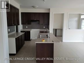 Haldimand apartment for rent - A kitchen with dark brown cabinets and a white countertop.