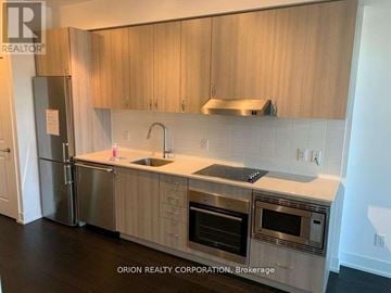 Toronto (Bayview Village) condo for rent - A kitchen with wooden cabinets and stainless steel appliances.