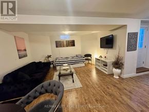 Richmond Hill (Westbrook) apartment for rent - A living room with a black couch, a zebra print bench, and a television.
