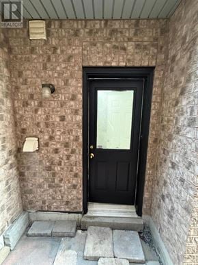 Milton (Cl Clarke) apartment for rent - A black door is at the end of a stone wall.