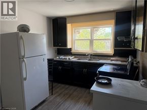Dunnville apartment for rent - A kitchen with a white fridge and black cabinets.
