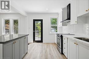 Hamilton apartment for rent - A modern kitchen with white cabinets and a black door.