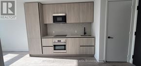 Toronto (Waterfront Communities) condo for rent - A modern kitchen with wooden cabinets and stainless steel appliances.