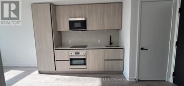 Toronto (Waterfront Communities) condo for rent - A modern kitchen with wooden cabinets and stainless steel appliances.