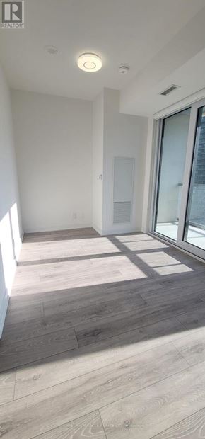 Toronto (Waterfront Communities) condo for rent - A room with a wooden floor and a window letting in sunlight.