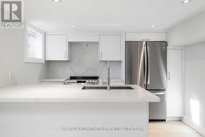 Toronto (Bedford Park-Nortown) apartment for rent - A modern kitchen with white cabinets and a stainless steel refrigerator.