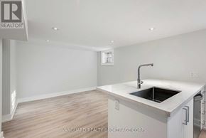 Toronto (Bedford Park-Nortown) apartment for rent - A white kitchen with a sink and a realtor sign.
