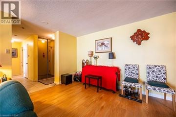 Waterloo condo for rent - A living room with a red couch and two chairs.